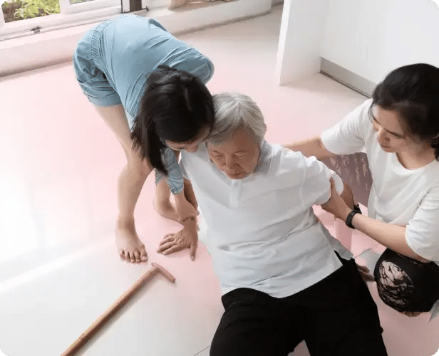 elderly woman being helped from falling by family