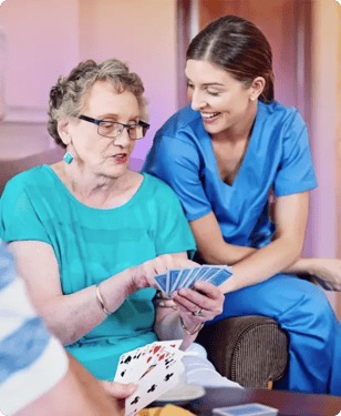 nurse playing cards with elderly woman and man