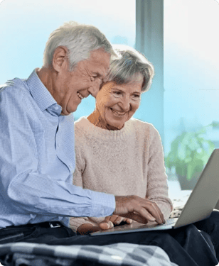 elderly couple looking at laptop together